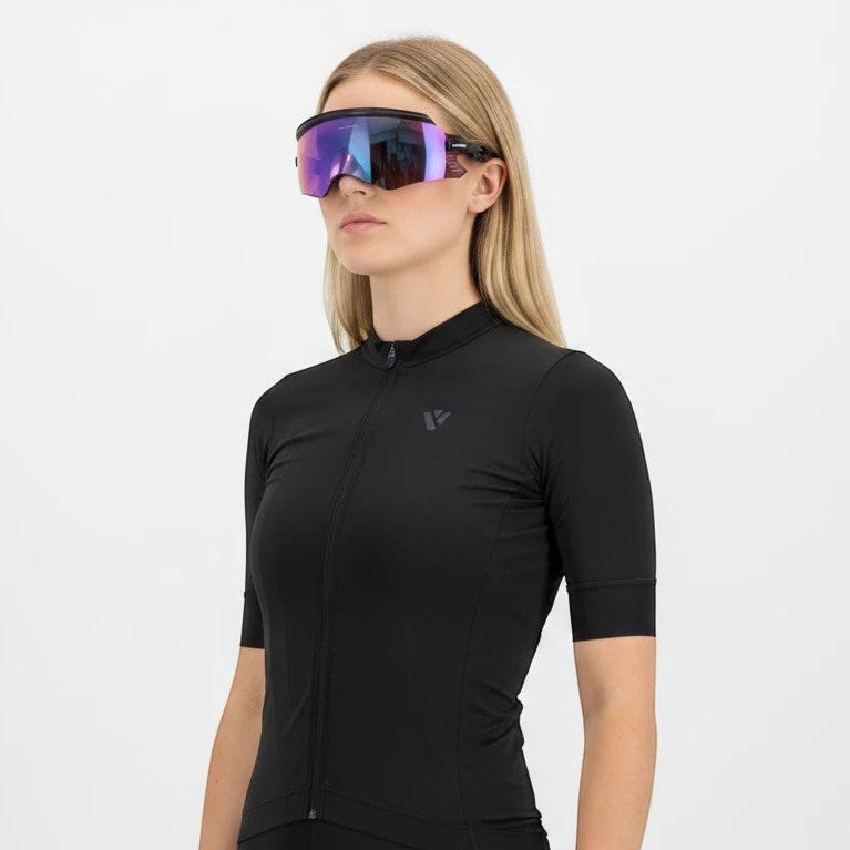 Velovoila cyclist wearing KAPVOE UV400 cycling sunglasses with a purple reflective shield lens and black frame
