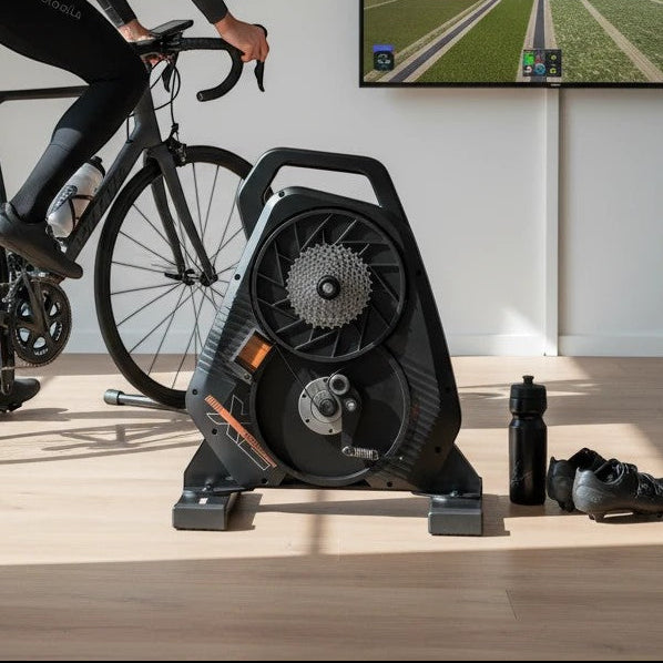 Cyclist using a Velovoila ThinkRider X2 MAX smart direct-drive bike trainer in a home gym with virtual cycling software.